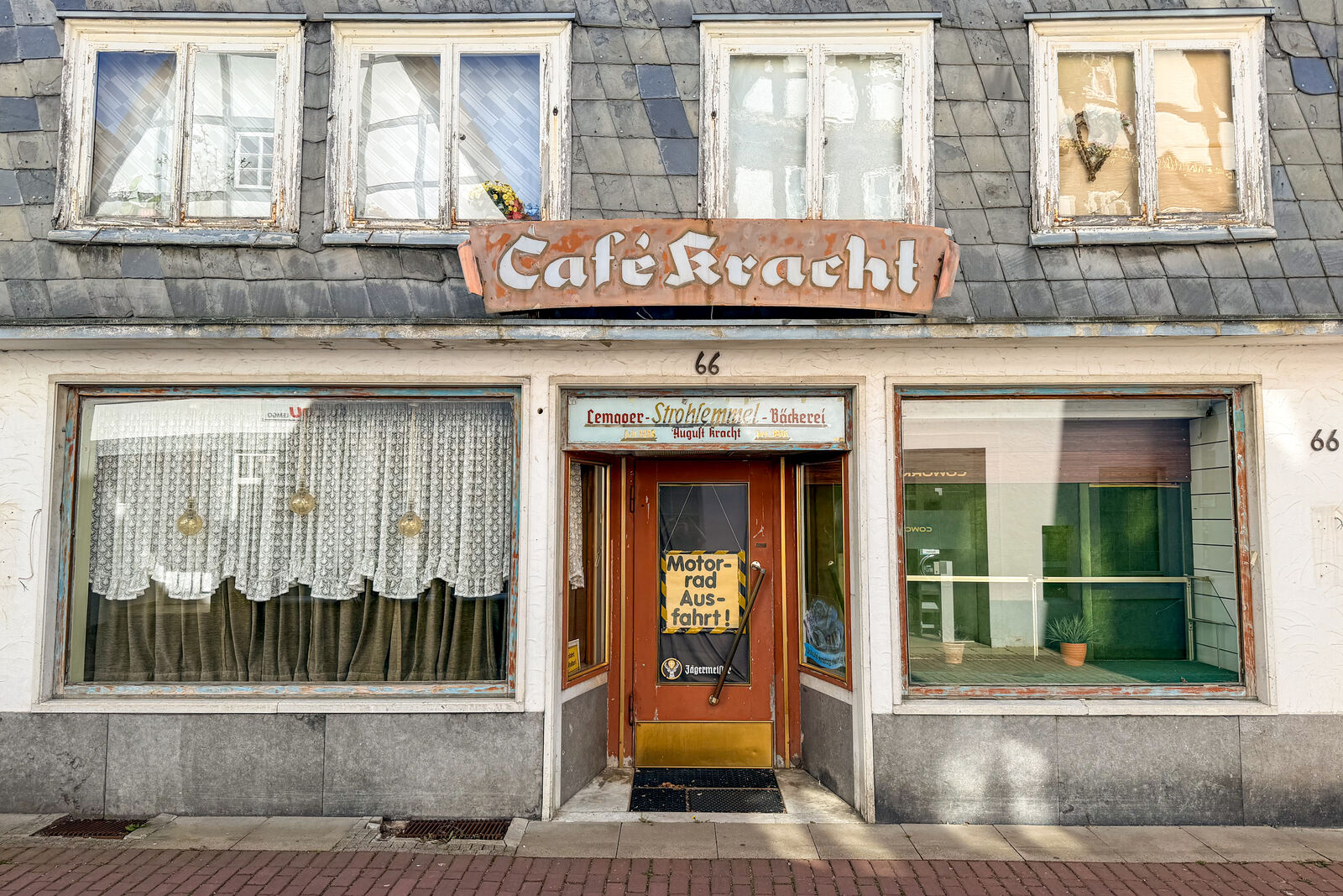 Verfallene Ladenfront eines Cafés mit Schild Motorrad Ausfahrt